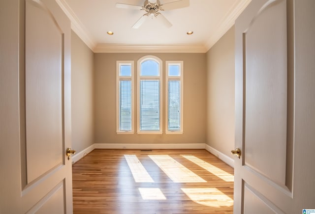 empty room featuring light hardwood / wood-style floors, ornamental molding, and ceiling fan