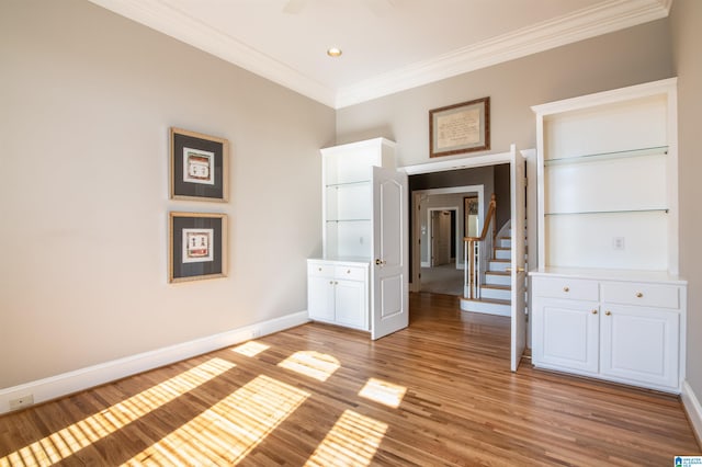 empty room with light hardwood / wood-style floors and crown molding