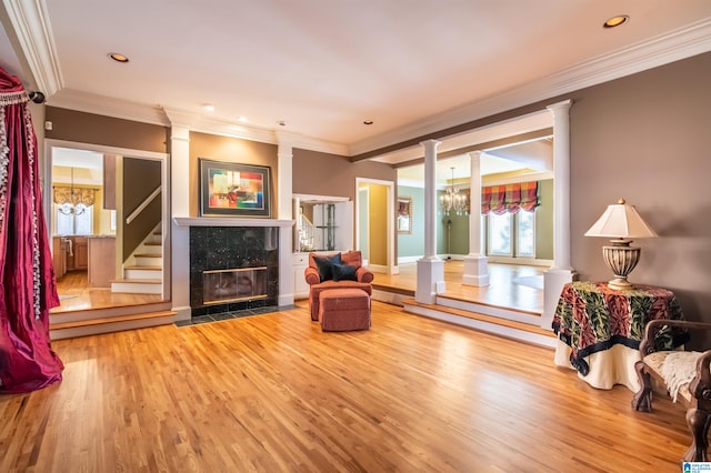 living area with ornamental molding, hardwood / wood-style floors, and ornate columns