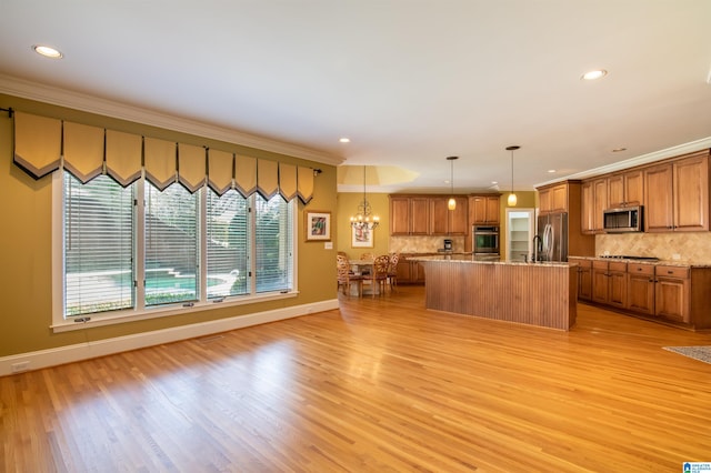 kitchen featuring a kitchen island, hanging light fixtures, light hardwood / wood-style floors, stainless steel appliances, and ornamental molding