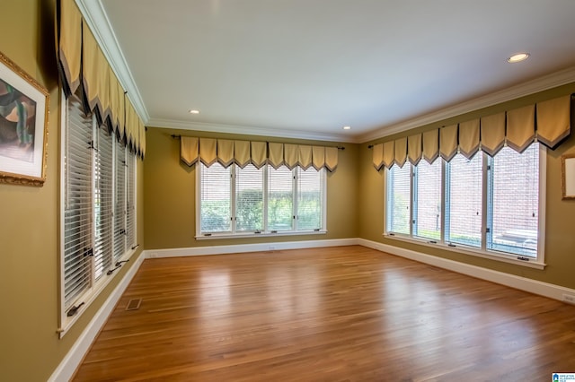 spare room featuring ornamental molding and hardwood / wood-style flooring