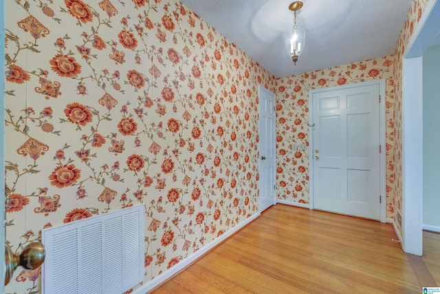 interior space featuring light hardwood / wood-style flooring and a textured ceiling