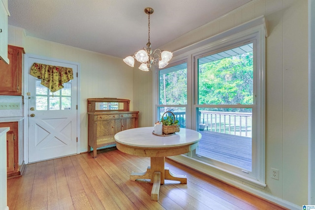 dining room with a wealth of natural light, a chandelier, and light wood-type flooring