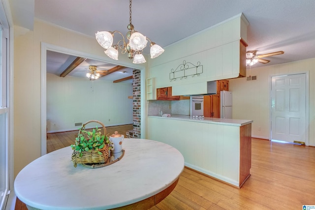 dining room featuring ceiling fan with notable chandelier, light hardwood / wood-style floors, brick wall, and beamed ceiling