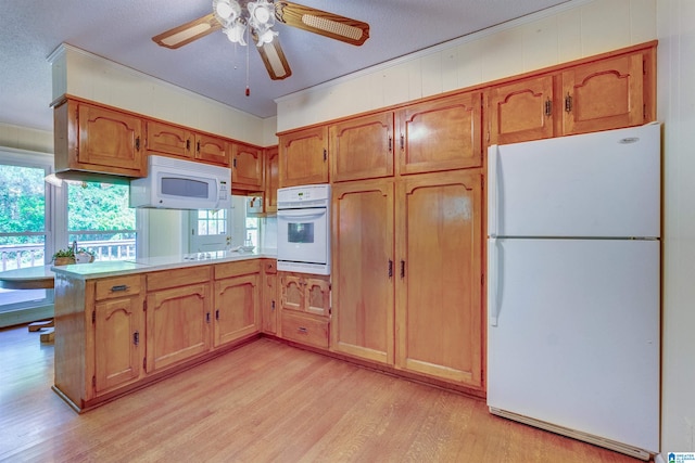 kitchen with white appliances, ceiling fan, light hardwood / wood-style floors, and kitchen peninsula