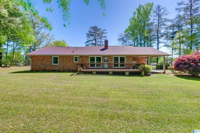 rear view of property featuring a deck and a yard