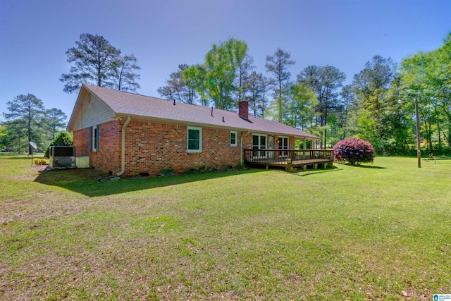 back of property featuring a wooden deck and a lawn