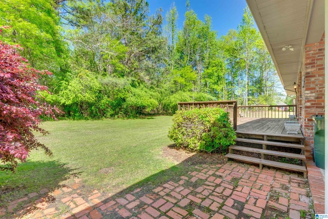 view of yard with a wooden deck and a patio