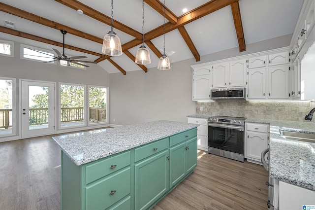 kitchen with green cabinets, sink, appliances with stainless steel finishes, and a center island