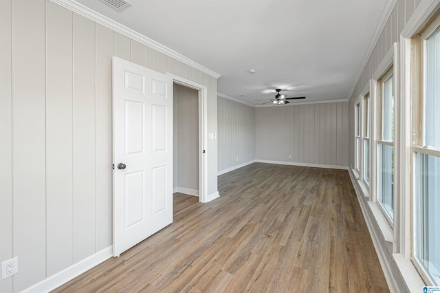 unfurnished room with hardwood / wood-style floors, ceiling fan, and crown molding