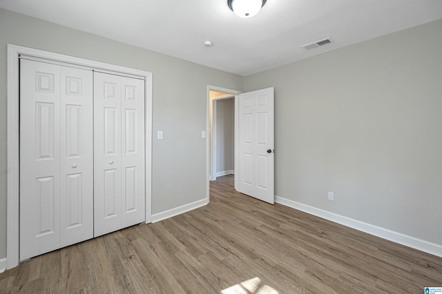 unfurnished bedroom featuring a closet and light wood-type flooring