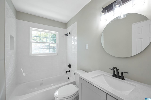 full bathroom featuring vanity, tiled shower / bath combo, and toilet