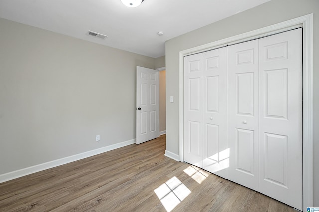 unfurnished bedroom with a closet and light wood-type flooring