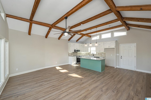 kitchen with stainless steel appliances, tasteful backsplash, hardwood / wood-style floors, a center island, and white cabinets