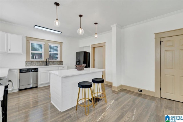 kitchen featuring black fridge, dishwasher, white cabinets, and a center island