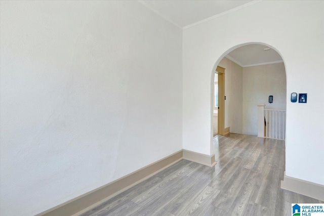 unfurnished room featuring light wood-type flooring and crown molding