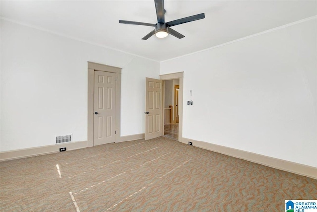 carpeted empty room featuring crown molding and ceiling fan