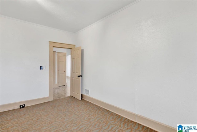 spare room with ornamental molding and light colored carpet