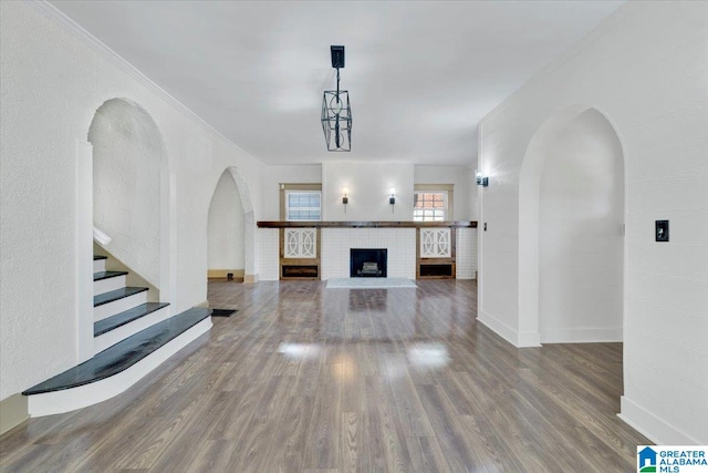 unfurnished living room with ornamental molding and hardwood / wood-style flooring