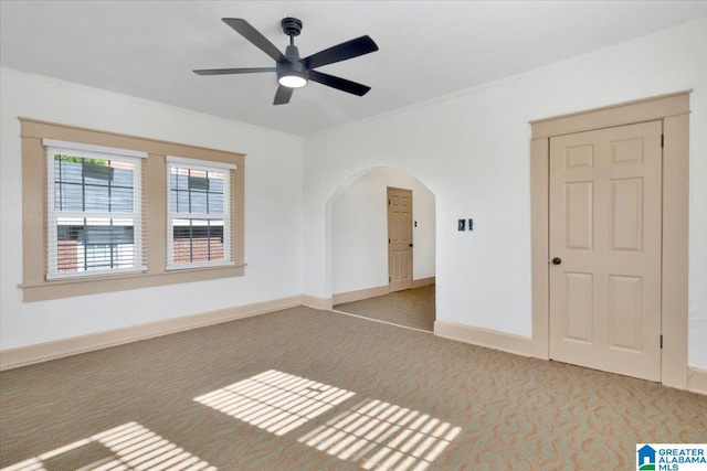 spare room with light carpet, crown molding, and ceiling fan