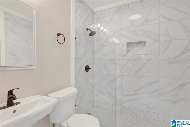 bathroom featuring sink, tiled shower, and toilet