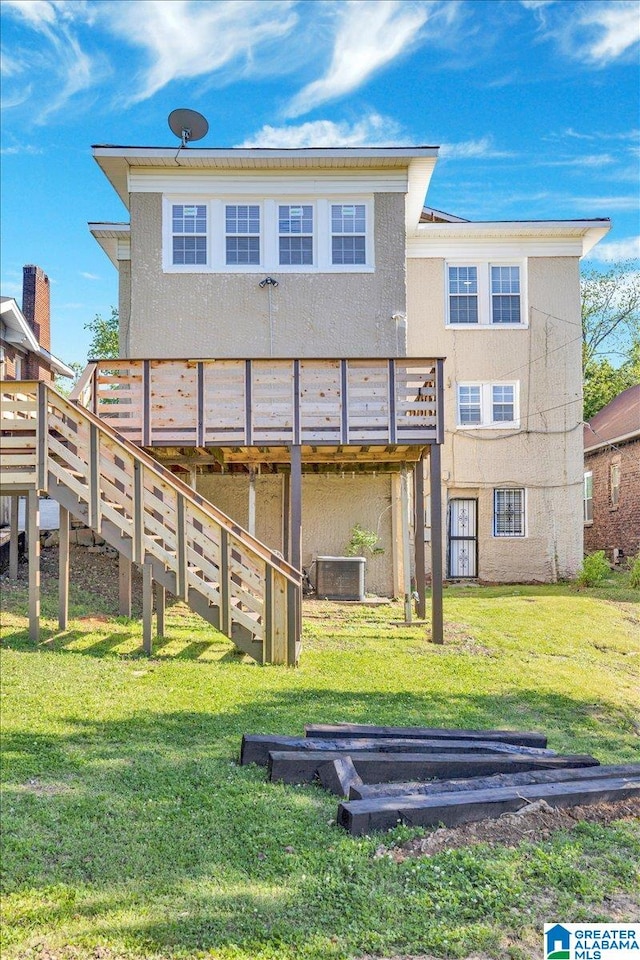 back of house with central air condition unit, a wooden deck, and a lawn