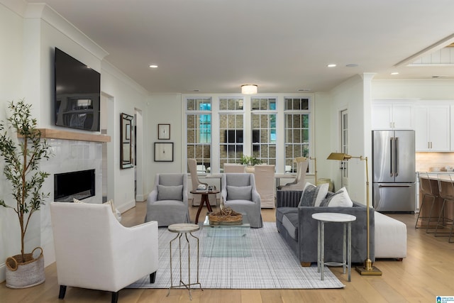 living room featuring french doors, light wood-type flooring, and crown molding