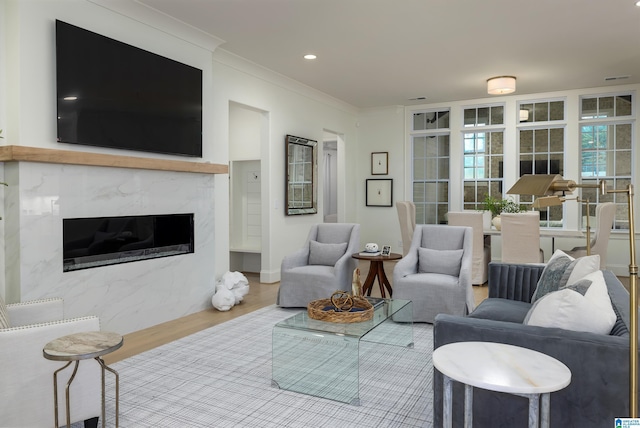 living room featuring hardwood / wood-style flooring, ornamental molding, and a fireplace