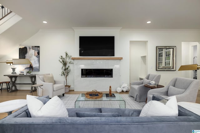 living room featuring light wood-type flooring, crown molding, and a premium fireplace