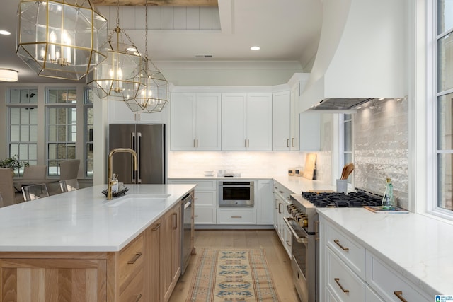 kitchen featuring white cabinets, an island with sink, custom range hood, and premium appliances