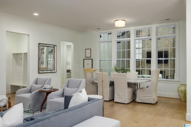 dining space with hardwood / wood-style flooring and ornamental molding