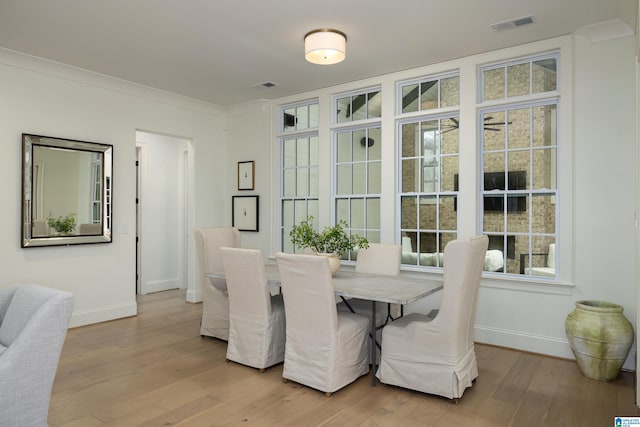 dining space featuring light hardwood / wood-style floors and ornamental molding