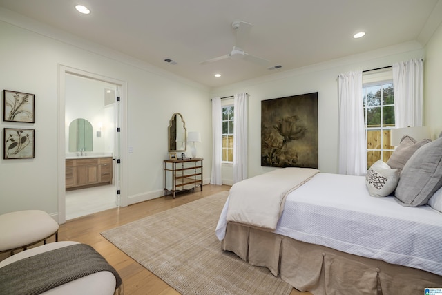 bedroom featuring ensuite bathroom, ornamental molding, ceiling fan, sink, and light hardwood / wood-style floors