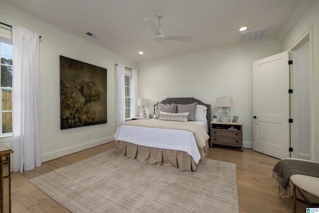 bedroom with multiple windows, ceiling fan, crown molding, and light wood-type flooring