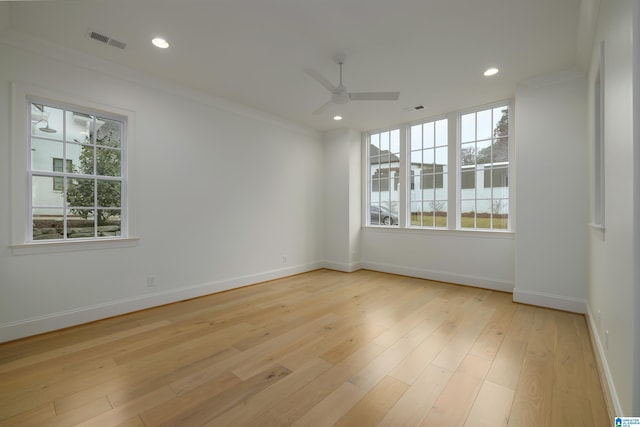 empty room with ceiling fan, light wood-type flooring, and ornamental molding