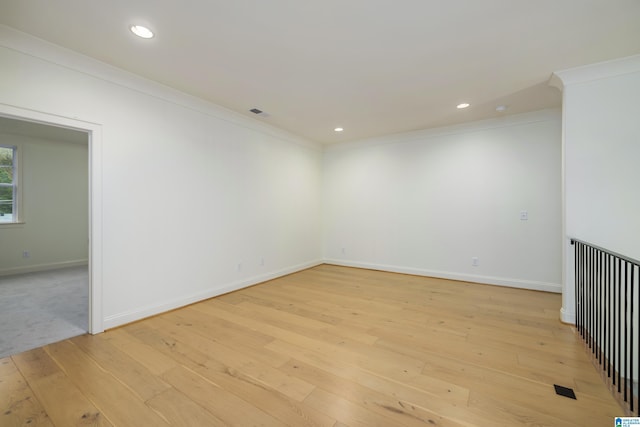 unfurnished room featuring crown molding and light wood-type flooring