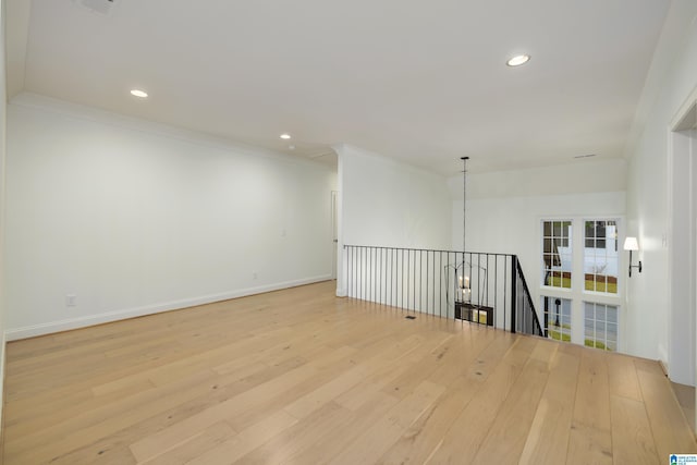 spare room featuring crown molding and light hardwood / wood-style floors