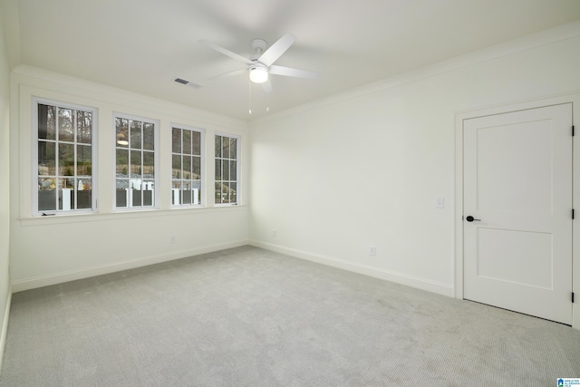 empty room with light colored carpet, ceiling fan, and crown molding