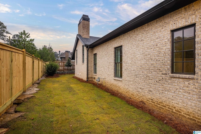 property exterior at dusk featuring a yard