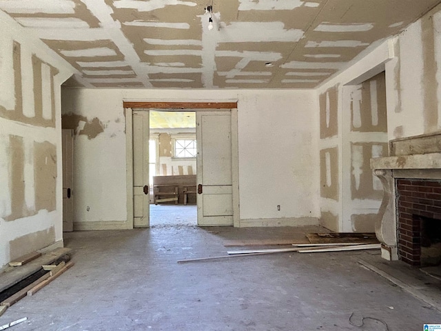 unfurnished living room featuring concrete flooring and a fireplace