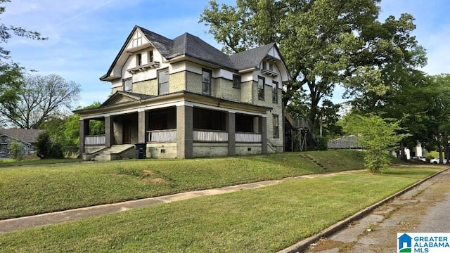 victorian-style house with a front yard and covered porch