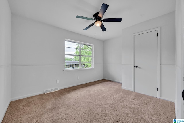 carpeted spare room featuring ceiling fan