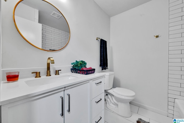 bathroom with toilet, vanity, and tile patterned floors