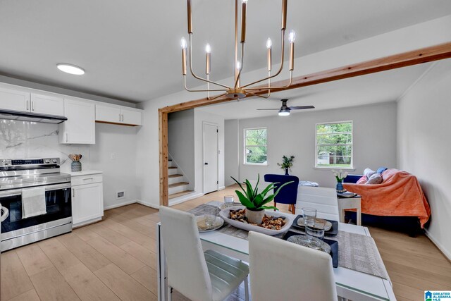 dining room featuring ceiling fan with notable chandelier and light hardwood / wood-style floors