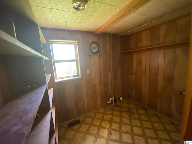 interior space featuring wooden walls and light tile floors