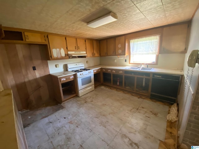 kitchen with white gas stove, black dishwasher, light tile floors, and sink