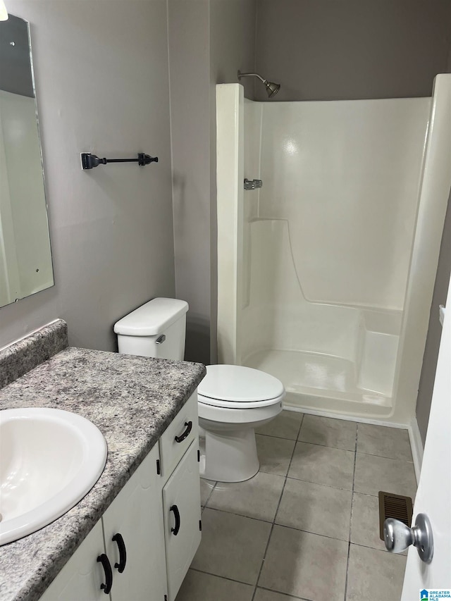 bathroom featuring walk in shower, vanity with extensive cabinet space, toilet, and tile flooring