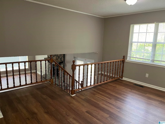 stairs featuring crown molding, dark hardwood / wood-style floors, and a textured ceiling