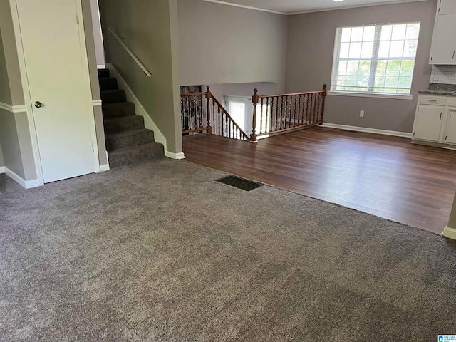 interior space with dark colored carpet and crown molding