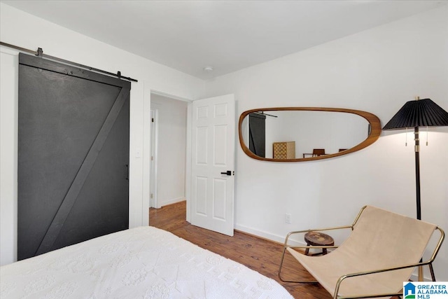 bedroom featuring hardwood / wood-style floors and a barn door